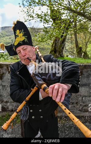 Ein traditioneller Gaiteiro aus Galicien, gekleidet in klassischer Kleidung mit Weste, weißem Hemd, knielanger Hose und breiter Krempe, spielt den Gaita, den legendären Dudelsack der Region. Dieser Musiker verkörpert das reiche kulturelle Erbe und die musikalischen Traditionen Galiciens und bringt lebendige Melodien in die festliche Atmosphäre lokaler Feiern Stockfoto