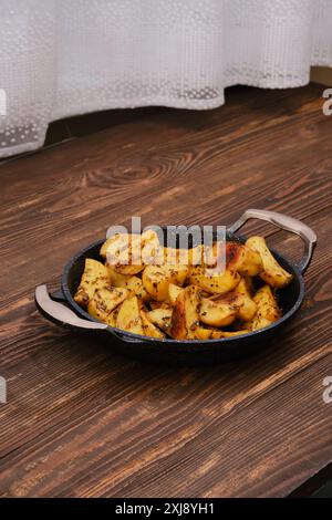 Gebackene Kartoffelscheiben mit Gewürzen, Kräutern und Knoblauch in der Backform Stockfoto