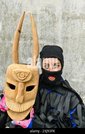 Eine traditionelle Maske aus Lazarim, Portugal, die aufwändig aus Holz geschnitzt wurde, symbolisiert das reiche kulturelle Erbe der Region. Diese Masken stehen im Mittelpunkt des Karnevals von Lazarim, der in alten heidnischen Ritualen verwurzelt ist, die das Ende des Winters und die Ankunft des Frühlings feiern und die tiefe Verbindung der Gemeinde zu ihren historischen Traditionen demonstrieren. Stockfoto