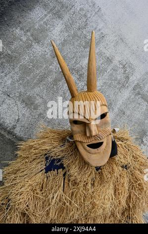 Eine traditionelle Maske aus Lazarim, Portugal, die aufwändig aus Holz geschnitzt wurde, symbolisiert das reiche kulturelle Erbe der Region. Diese Masken stehen im Mittelpunkt des Karnevals von Lazarim, der in alten heidnischen Ritualen verwurzelt ist, die das Ende des Winters und die Ankunft des Frühlings feiern und die tiefe Verbindung der Gemeinde zu ihren historischen Traditionen demonstrieren. Stockfoto