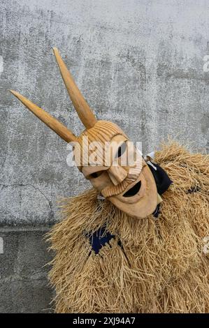 Eine traditionelle Maske aus Lazarim, Portugal, die aufwändig aus Holz geschnitzt wurde, symbolisiert das reiche kulturelle Erbe der Region. Diese Masken stehen im Mittelpunkt des Karnevals von Lazarim, der in alten heidnischen Ritualen verwurzelt ist, die das Ende des Winters und die Ankunft des Frühlings feiern und die tiefe Verbindung der Gemeinde zu ihren historischen Traditionen demonstrieren. Stockfoto