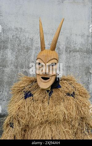 Eine traditionelle Maske aus Lazarim, Portugal, die aufwändig aus Holz geschnitzt wurde, symbolisiert das reiche kulturelle Erbe der Region. Diese Masken stehen im Mittelpunkt des Karnevals von Lazarim, der in alten heidnischen Ritualen verwurzelt ist, die das Ende des Winters und die Ankunft des Frühlings feiern und die tiefe Verbindung der Gemeinde zu ihren historischen Traditionen demonstrieren. Stockfoto