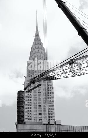 Das glänzende Chrysler Building aus Metall und Glas ist der Art déco-Wolkenkratzer von der 42. Straße aus mit einem Kranausleger im Vordergrund Stockfoto