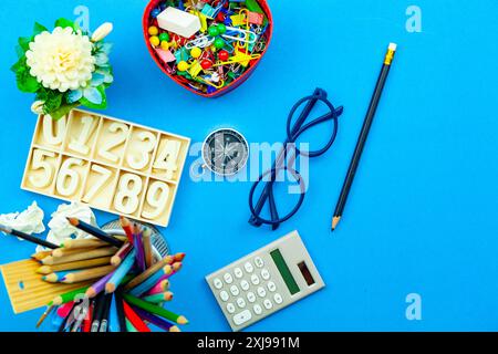 Zurück zum Schulhintergrund mit Schulmaterial auf blauem Papierhintergrund, bereit für Ihr Design und Kopierraum für Ihren Text Stockfoto