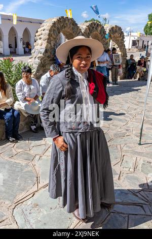 Ein junger weiblicher Gaucho, oder china, in ihrem traditionellen Outfit mit dem roten Salteño Poncho in Cachi, Argentinien. "China" ist ein indigenes Quechua-Wort Stockfoto