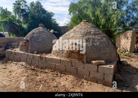 Zwei große traditionelle lehm- und Schlammöfen oder Hornos, die jeweils eine ganze Kuh im Inneren für ein Gaucho-Treffen in Cachi, Argentinien, braten. Stockfoto