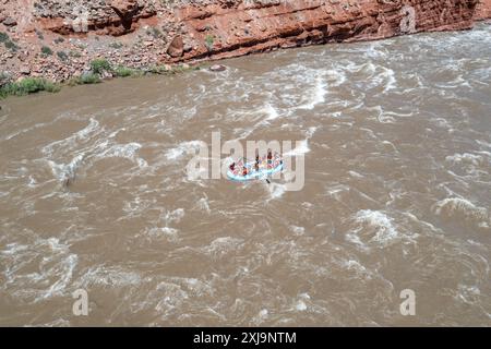 Touristen genießen eine geführte Rafting-Tour durch die großen Wellen in White's Rapid auf dem Colorado River am Hochwasser. Moab, Utah. Stockfoto