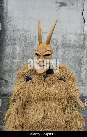 Eine traditionelle Maske aus Lazarim, Portugal, die aufwändig aus Holz geschnitzt wurde, symbolisiert das reiche kulturelle Erbe der Region. Diese Masken stehen im Mittelpunkt des Karnevals von Lazarim, der in alten heidnischen Ritualen verwurzelt ist, die das Ende des Winters und die Ankunft des Frühlings feiern und die tiefe Verbindung der Gemeinde zu ihren historischen Traditionen demonstrieren. Stockfoto