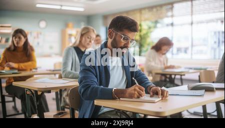 Multiethnischer indischer Mann, der neue akademische Fähigkeiten im Unterricht mit anderen Menschen erwirbt. Formelle Lernaktivität für Erwachsene, die von verschiedenen reiferen Schülern nach Abschluss der Schule oder Hochschule durchgeführt wird. Stockfoto