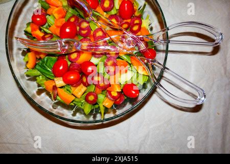 Blick von oben auf einen gemischten Salat in einer Schüssel mit Salatservieren. Farbenfrohe frisch gepflückte und zubereitete Zutaten. Stockfoto