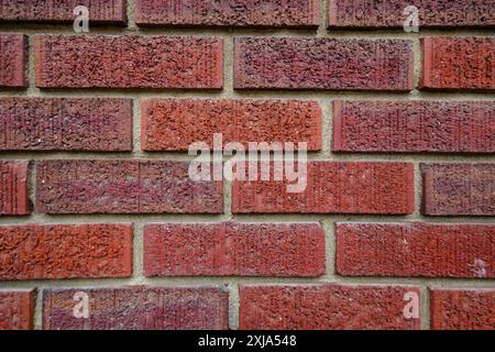 Nahaufnahme einer alten, tonroten Ziegelmauer, in einem laufenden Bindungsmuster mit Mörtel horizontal, gemauertem Muster. Stockfoto