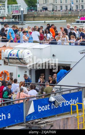 Die Leute warten in London an und warten auf eine Bootsfahrt, da viele Touristen während der Sommerferien die Hauptstadt besuchen werden. Stockfoto