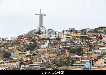 Coquimbo, Chile - 15. März 2019: Lebhafte Häuser am Hügel unter dem hoch aufragenden Kreuz. Stockfoto