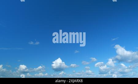 Zeitraffer. Wolken, die über den blauen Himmel laufen. Weiße, geschwollene und flauschige Wolken am blauen Himmel. Stockfoto