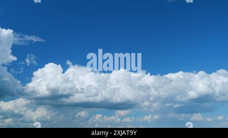 Zeitraffer. Wolken, die über den blauen Himmel laufen. Weiße, geschwollene und flauschige Wolken am blauen Himmel. Stockfoto