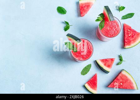 Frischer Wassermelonensaft mit Minze in Gläsern auf blauem Hintergrund, Draufsicht, Kopierraum. Süßer Sommer-Smoothie, Detox-Cocktail, Bio gesunde Lebensmittel. Stockfoto