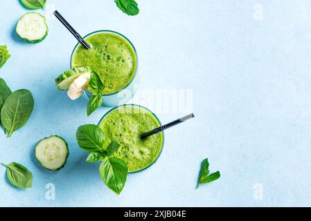 Detox Green Smoothie in Gläsern auf hellblauem Hintergrund, Draufsicht, Kopierraum. Gesundes sauberes Essen, veganes Lifestyle Konzept. Stockfoto