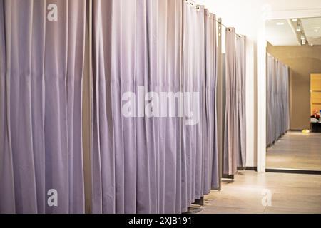 Moderner Umkleideraum mit grauen Vorhängen in einem Bekleidungsgeschäft. Stockfoto
