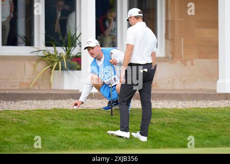 17. Juli 2024; Royal Troon Golf Club, Troon, South Ayrshire, Schottland; Open Championship Practice Day 3; Nicolai Hojgaard&#x2019;s Caddy holt einen Ball aus dem Kies zwischen dem Platz und dem Clubhaus auf dem 18. Grün Stockfoto