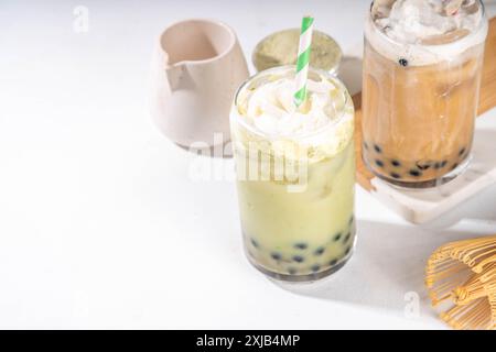 Klassischer und grüner Matcha boba-Bubble-Tee mit Tapioka-Perlen und Schlagsahne auf Glas, sommerkalter süßer Dessertdrink auf weißem t Stockfoto