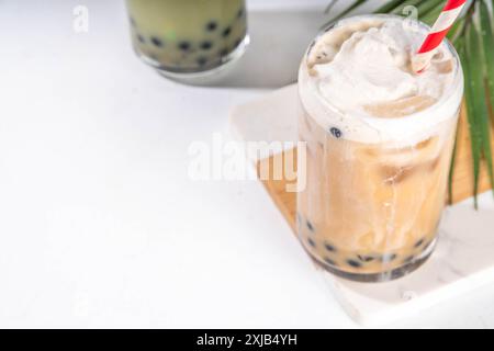 Klassischer und grüner Matcha boba-Bubble-Tee mit Tapioka-Perlen und Schlagsahne auf Glas, sommerkalter süßer Dessertdrink auf weißem t Stockfoto