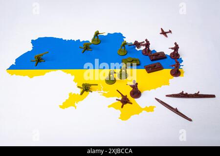 Karte der Ukraine in den Farben der Flagge mit Figuren, die Soldaten und militärische Ausrüstung darstellen. Illustration des Krieges zwischen Russland und der Ukraine Stockfoto