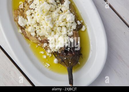 Mediterrane Küche, geröstete Auberginen gefüllt mit Fetakäse in Olivenöl Stockfoto