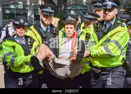 London, Großbritannien. Juli 2024. Polizeibeamte verhaften einen pro-palästinensischen Demonstranten aus der Gruppe Youth Demand vor der Parlamentseröffnung in London. Die Demonstranten versammelten sich in den Victoria Embankment Gardens und planten, die Eröffnung des Staates zu stören, so ihre Social-Media-Beiträge. Quelle: Vuk Valcic/Alamy Live News Stockfoto