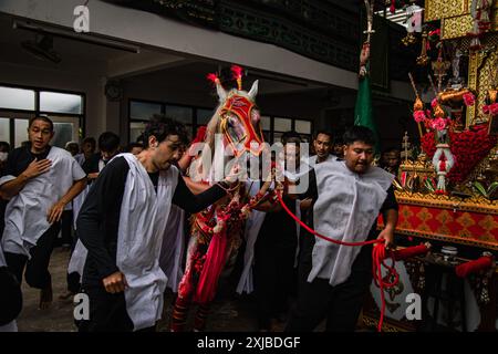 Bangkok, Bangkok, Thailand. Juli 2024. 17. Juli 2024, Bangkok, Thailand Schiiten Muslime spielen die Szene nach, indem sie das Pferd während einer religiösen Prozession am zehnten Tag der Ashura in der Phadungtham Islam Mosgue, Bangkok, Thailand, berühren. Die Trauer um Muharram ist eine Reihe von Ritualen zur Erinnerung an das Martyrium des Propheten Mohammads Enkel Imam Hussain aus dem siebten Jahrhundert, der 680 n. Chr. in der Schlacht von Karbala im heutigen Irak getötet wurde. (Kreditbild: © Wissarut Weerasopon/ZUMA Press Wire) NUR REDAKTIONELLE VERWENDUNG! Nicht für kommerzielle ZWECKE! Stockfoto