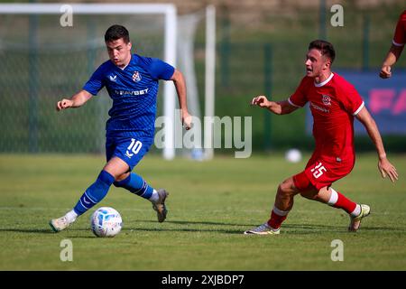 Lendava, Slowenien. Juli 2024. Martin Baturina von Dinamo Zagreb läuft mit dem Ball unter Druck von Oleksandr Drambaev von Kryvbas KR während des internationalen Freundschaftsspiels zwischen GNK Dinamo Zagreb und dem FC Kryvbas Kryvyi Rih am 17. Juli 2024 im Sportpark Lendava, Slowakei. Foto: Matija Habljak/PIXSEL Credit: Pixsell/Alamy Live News Stockfoto