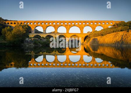 Sonnenaufgang am Pont du Gard, einem römischen Aquädukt über dem Gardon River, der später zu einer Brücke ausgebaut wurde. Das Gebäude befindet sich in der Nähe der Stadt Ver Stockfoto