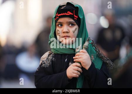 Ein irakisches schiitisches muslimitisches Kind schmierte ihr Gesicht mit Schlamm, während er an Trauerritualen während einer religiösen Prozession vor dem Ashura-Tag in der Nähe des Heiligtums von Imam Hussein teilnahm. Muharram gilt als ein Monat der Trauer und Erinnerung an schiitische Muslime auf der ganzen Welt, in dem sie dem Martyrium des Enkels des islamischen Propheten Mohammad, Hussein ibn Ali, gedenken, der in der Schlacht von Karbala im 7. Jahrhundert getötet wurde. Stockfoto