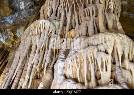 Ein detaillierter Blick auf Stalaktiten in einer Höhle, gekennzeichnet durch langgezogene, tropfende Formationen aus Kalkstein und Mineralablagerungen, die an der Decke der Höhle hängen Stockfoto