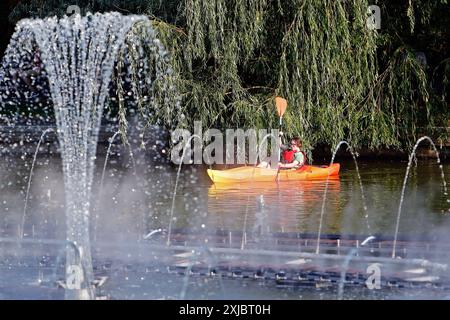 Bukarest, Rumänien. Juli 2024. Eine Frau fährt am 17. Juli 2024 in einem Park in Bukarest, Rumänien, Kanu. Die rumänische nationale Meteorologische Verwaltung (ANM) hat ihre roten und orangen Hitzewarnungen bis Mittwoch verlängert, was das gesamte Land während einer andauernden Hitzewelle betrifft. Quelle: Cristian Cristel/Xinhua/Alamy Live News Stockfoto