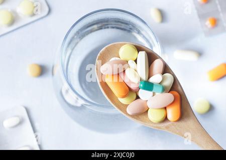 Bunte Tablette, Kapseln, Pillen Medizin im Holzlöffel, Gesundheitswesen und medizinisches Konzept Stockfoto