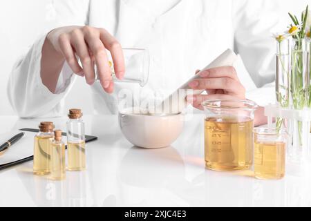 Aromatherapeutikum. Wissenschaftler, der ätherische Öle am weißen Tisch im Labor entwickelt, Nahaufnahme Stockfoto