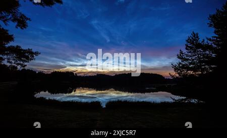 Sonnenaufgang über dem See und nächtliche Wolken Stockfoto