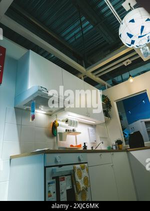 Paris, Frankreich - 12. Juli 2024: Flacher Blick auf eine kleine Küche in einem IKEA-Möbelgeschäft mit Motorhaube und allen wichtigen Geräten in kompaktem und funktionalem Design Stockfoto