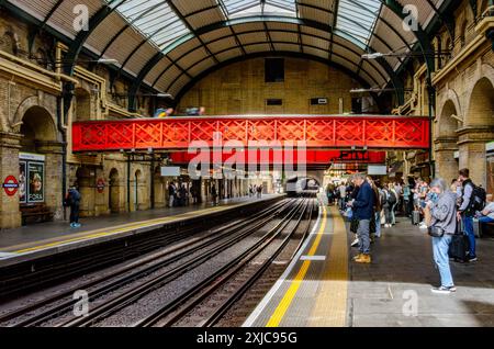 Passagiere warten auf einen Zug am Bahnsteig der Londoner U-Bahn-Station Paddington Stockfoto