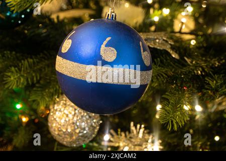 Nahaufnahme einer blauen und silbernen Kugel, die an einem Weihnachtsbaum hängt Stockfoto