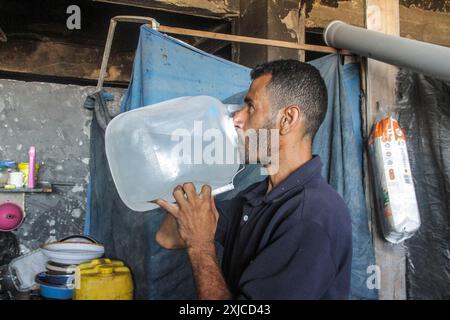 Gaza. Juli 2024. Ein Familienmitglied von Ahmed Shinbari trinkt am 17. Juli 2024 Wasser in den nördlichen Teilen des Gazastreifens. Etwa 67 Prozent der Wasser-, Sanitär- und Infrastruktur im Gazastreifen wurden zerstört oder beschädigt, sagte das Hilfswerk der Vereinten Nationen für Palästinaflüchtlinge im Nahen Osten (UNRWA) auf der Social-Media-Plattform X im Juni. Quelle: Mahmoud Zaki/Xinhua/Alamy Live News Stockfoto