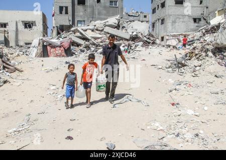 Gaza. Juli 2024. Familienangehörige von Ahmed Shinbari holen am 17. Juli 2024 Wasser in den nördlichen Teilen des Gazastreifens. Etwa 67 Prozent der Wasser-, Sanitär- und Infrastruktur im Gazastreifen wurden zerstört oder beschädigt, sagte das Hilfswerk der Vereinten Nationen für Palästinaflüchtlinge im Nahen Osten (UNRWA) auf der Social-Media-Plattform X im Juni. Quelle: Mahmoud Zaki/Xinhua/Alamy Live News Stockfoto