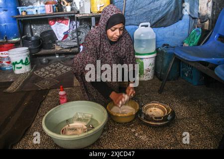 Gaza. Juli 2024. Ein Familienmitglied von Ahmed Shinbari wäscht am 17. Juli 2024 Geschirr in den nördlichen Teilen des Gazastreifens. Etwa 67 Prozent der Wasser-, Sanitär- und Infrastruktur im Gazastreifen wurden zerstört oder beschädigt, sagte das Hilfswerk der Vereinten Nationen für Palästinaflüchtlinge im Nahen Osten (UNRWA) auf der Social-Media-Plattform X im Juni. Quelle: Mahmoud Zaki/Xinhua/Alamy Live News Stockfoto