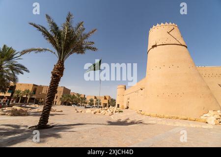 Riad, Saudi-Arabien: Saudische Nationalflagge fliegt an einem sonnigen Tag über dem berühmten Masmak-Fort in der Altstadt von Riad in der Hauptstadt Saudi-Arabiens. Stockfoto