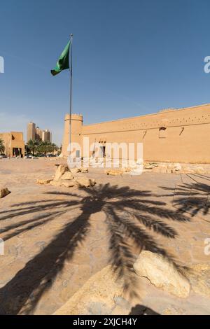 Riad, Saudi-Arabien: Saudische Nationalflagge fliegt an einem sonnigen Tag über dem berühmten Masmak-Fort in der Altstadt von Riad in der Hauptstadt Saudi-Arabiens. Stockfoto