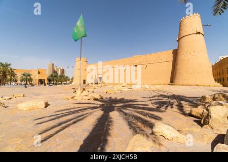 Riad, Saudi-Arabien: Saudische Nationalflagge fliegt an einem sonnigen Tag über dem berühmten Masmak-Fort in der Altstadt von Riad in der Hauptstadt Saudi-Arabiens. Stockfoto