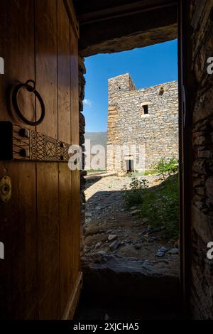 Al Bahah, Saudi-Arabien: Ein Blick durch eine alte Holztür auf das antike Dorf Thee Ain oder Zee Ain in Saudi-Arabien in der Nähe von Dschidda. Stockfoto