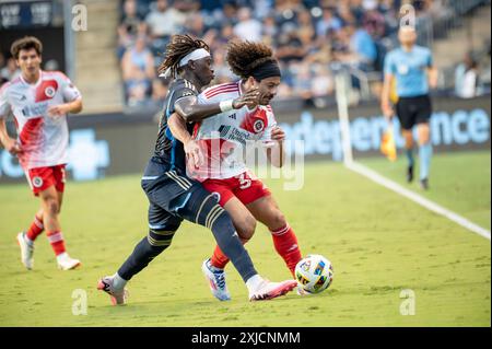 Chester, Pennsylvania, USA. Juli 2024. Philadelphia Union Spieler OLIVER MBAIZO (15) kämpft während des Spiels um den Ball gegen den New England Revolution Spieler RYAN SPAULDING (34) (Bild: © Ricky Fitchett/ZUMA Press Wire) NUR FÜR REDAKTIONELLE ZWECKE! Nicht für kommerzielle ZWECKE! Stockfoto