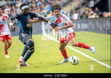 Chester, Pennsylvania, USA. Juli 2024. Philadelphia Union Spieler OLIVER MBAIZO (15) kämpft während des Spiels um den Ball gegen den New England Revolution Spieler RYAN SPAULDING (34) (Bild: © Ricky Fitchett/ZUMA Press Wire) NUR FÜR REDAKTIONELLE ZWECKE! Nicht für kommerzielle ZWECKE! Stockfoto