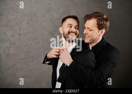 Zwei Männer in Anzügen umarmen und lachen zusammen, ihre Gesichter voller Freude. Stockfoto